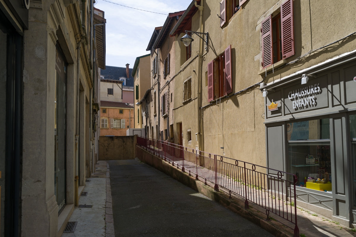a narrow city street with a store on the side