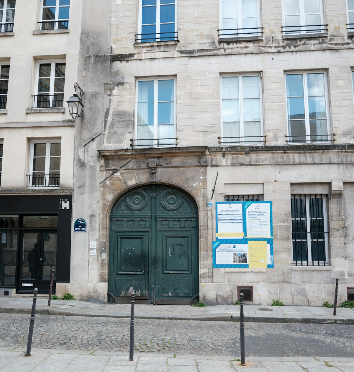 Ornate green double doors on a stone building facade
